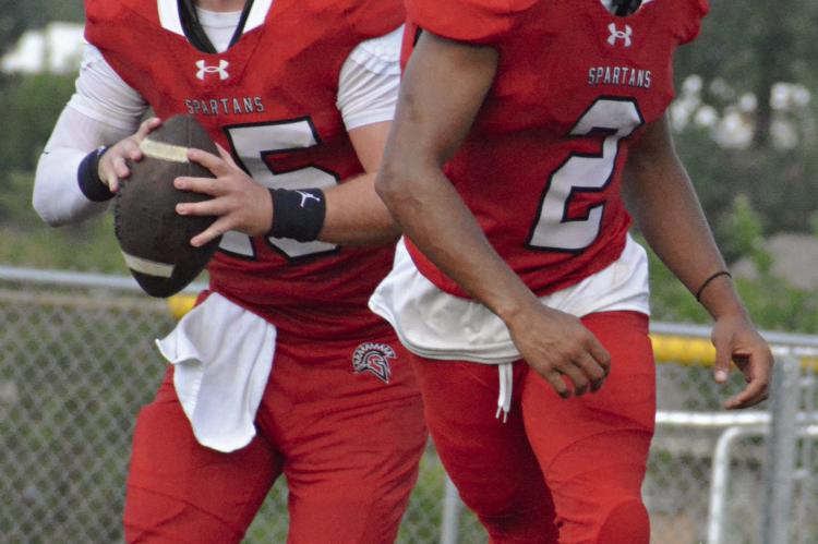 RED TEAM QUARTERBACK Jacob Lieberknecht (left) rolls out with running back Cyrus Jackson in front. Jackson contributed a third-quarter TD run in the Red Team’s one-point loss to the White Team in Richmond’s annual Red and White Game.