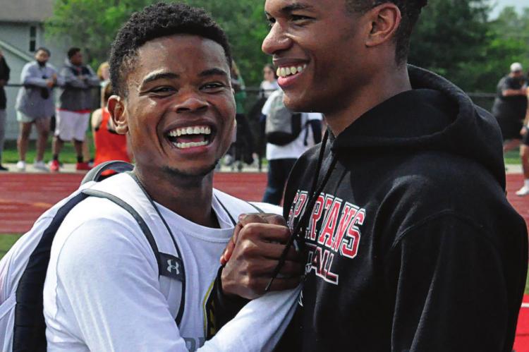 ADRIAN CHURCH, left, and Jordan Alexander enjoy the news of hearing they, along with teammates Layne Cavanah and Keyshaun Elliott, have broken Richmond’s school record in the boys 400-meter relay. SHAWN RONEY | Staff