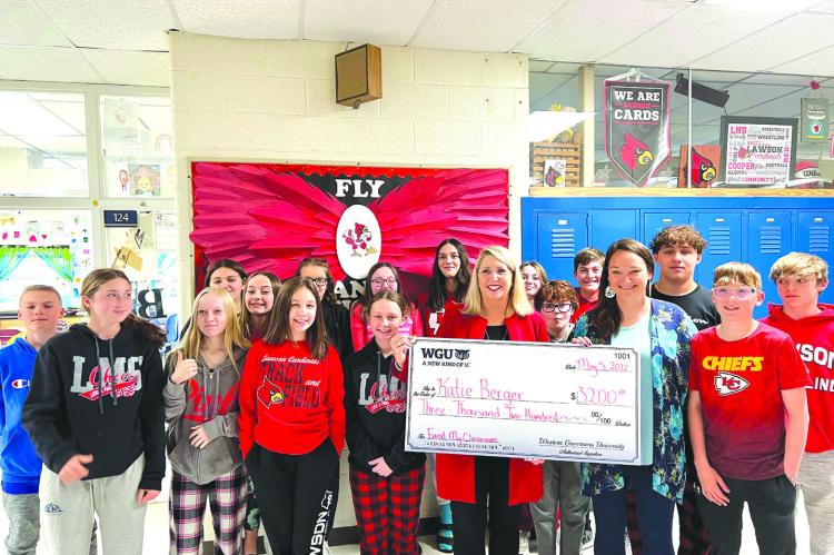 KATIE BERGER, in blue, along with her eighth-grade class, accepts a check from Angie Besendorf, WGU Missouri chancellor. SUBMITTED