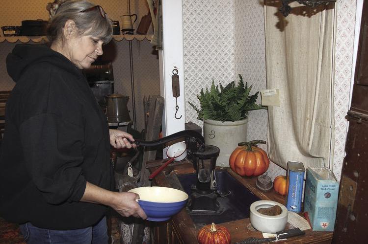 AT THE RAY COUNTY Museum, manager Cathy Gottsch is in Grandma’s Kitchen, a museum room, to show how an old hand pump could be used to wash dishes in an indoor sink.