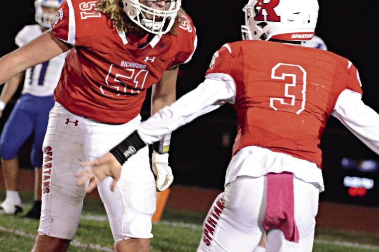 RICHMOND SENIOR lineman Jack Gogue, No. 51, seen celebrating in October 2022 with quarterback Donivin Williams, plans to continue his football career at New Mexico State University. SHAWN RONEY | Staff
