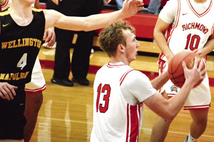 SOPHOMORE CALEB MOYER (center) is pursued by Wellington-Napoleon senior Brody Best as Richmond teammate Gabriel Ramos watches. SHAWN RONEY | Staff