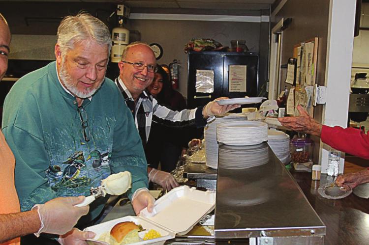 AT THE 2019 Thanksgiving Dinner, from left, Pastors Rance Williams, Eddie Birdsong and Phillip Powers work together to prepare a plate for Lloyd Walker. J.C. VENTIMIGLIA | Staff