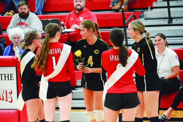 FROM LEFT, with their backs to the camera, Richmond seniors Alli Powell, Kelly Jaggars and Sara Brungardt give a yellow rose apiece Tuesday night to Cameron seniors Claire Wenk, No. 4, and Jessica Kirkendoll on Senior Night at Richmond High School. SHAWN RONEY | Staff