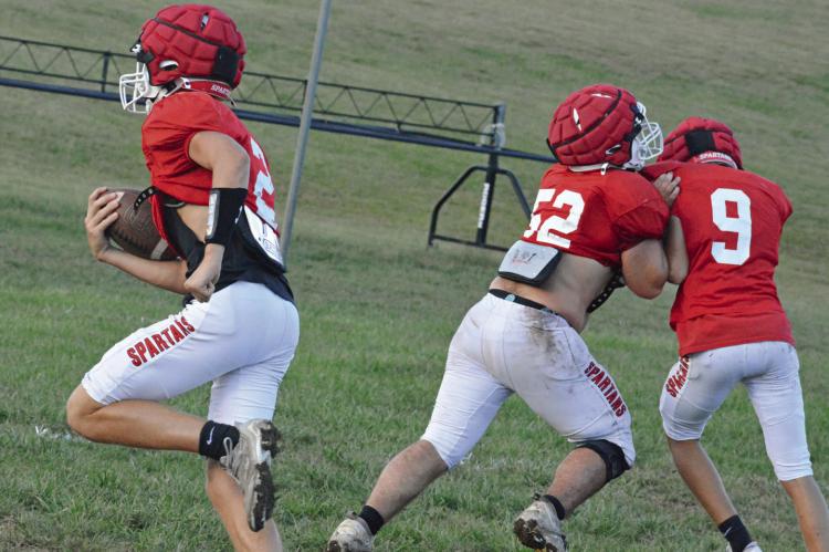 BRYER FARNAN (No. 2) bolts for the end zone as Landon Garrett (No. 52) blocks Mattox McCloud Tuesday on the Richmond practice field. SHAWN RONEY | Staff