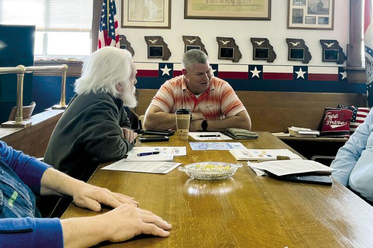 RAY COUNTY COMMISSIONERS GARY WILHITE, Dave Powell and Billy Gaines discuss the rebranding of Ray County Memorial Hospital. Hospital CEO Jeff Bloemker (right) is seeking letters of support. SOPHIA BALES | Staff
