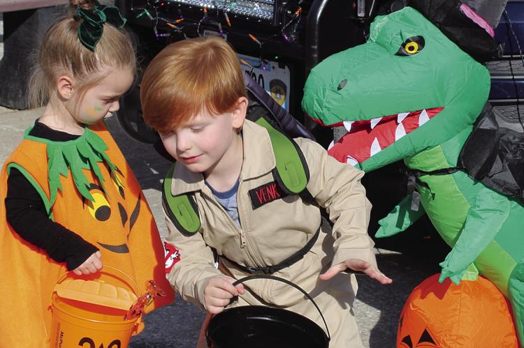 KATRINA RICHARDS (left) watches Asher Hazelman run from the dino during the event. SHARON DONAT | Staff