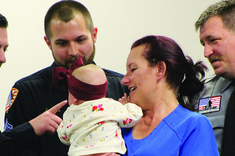 FIRST RESPONDERS interact with baby Everly and her aunt during the Life Saver Award ceremony recognizing local emergency crews. SHARON DONAT | Staff
