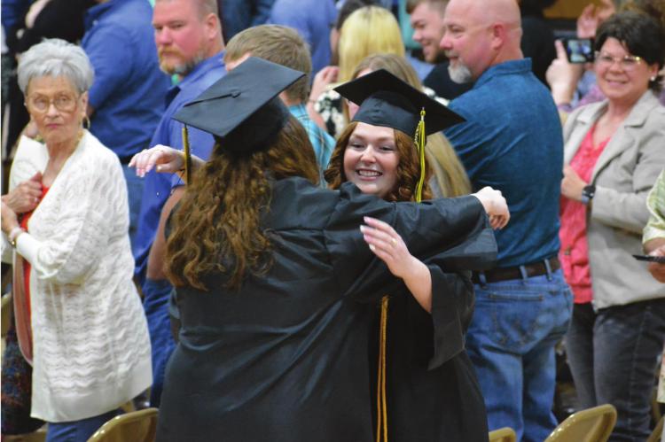 SAVANNAH BARTLEY hugs a classmate during the opening processional. SHAWN RONEY | Staff