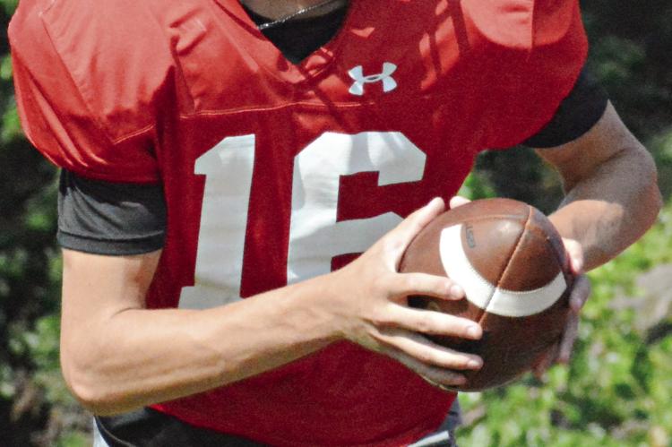 AFTER STUDYING VIDEO with his teammates, Richmond quarterback Jacob Johnson looks to pitch as the Spartans go through running game drills Monday on their practice field. SHAWN RONEY | Staff