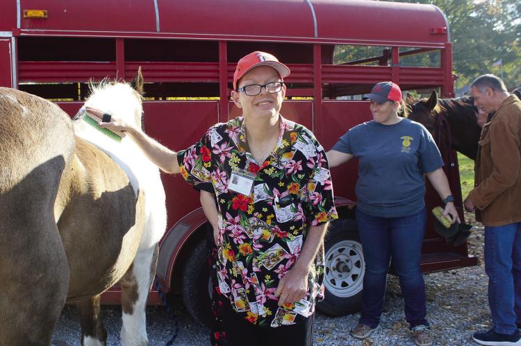 SHARON DONAT | Staff JOHN BUCHER enjoys brushing a horse during the FFA petting zoo at Ideal Industries.