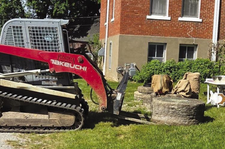 VOLUNTEERS PLACE the newly donated column piece on the Ray County Museum lawn. Submitted