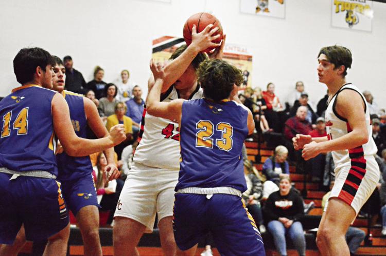 HOLDING THE BALL above his head, Hardin-Central junior Jesse Doyle tries to muscle his way through the Northwestern of Mendon defense Dec. 15 during Hardin-Central’s 53-33 home loss. SHAWN RONEY | Staff