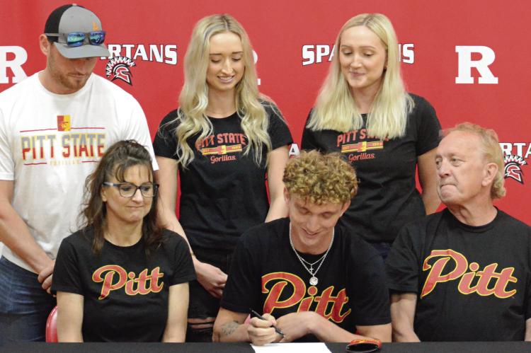 RICHMOND SENIOR Jacob Johnson (front row, center) signs his letter of intent to attend and compete in men’s track at Pittsburg (Kan.) State University as his proud family watches. Also on the front are (from left) parents Stephanie and Kelly Johnson. On the back row are his brother-in-law, Sawyer Junker; sister, Brittany Junker; and sister, Nicole Johnson. SHAWN RONEY | Staff