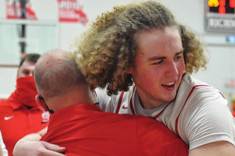 IN VICTORY, coach Kevin Jermain gets a hug from sophomore Jack Gogue. SHAWN RONEY | Staff