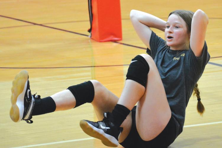 KELLY JAGGARS does her bicycle crunches Monday morning during volleyball camp in the Richmond High School gym. SHAWN RONEY | Staff
