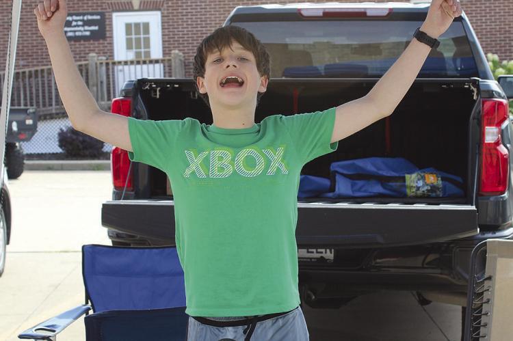 LOGAN SHELTON enthusiastically greets visitors at his popcorn booth. See more on Page 7 of today’s edition. SHARON DONAT | Staff