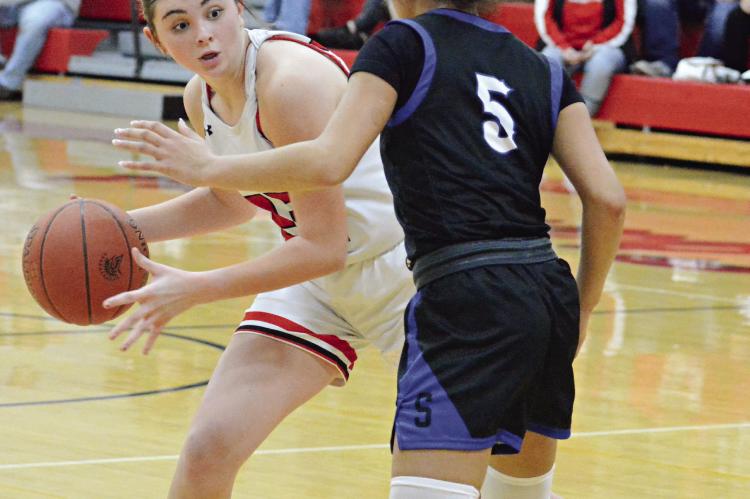 RICHMOND SOPHOMORE Emma Hash looks to pass around Summit Christian Academy sophomore Aaliyah Daniels Dec. 14 in varsity girls basketball action at Richmond. SHAWN RONEY | Staff