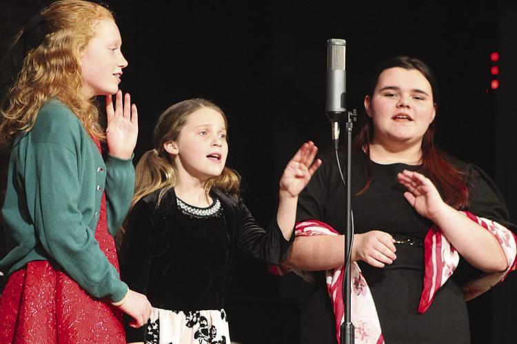 ANNA GARLAND (from left), Paige Quick and Isabella Hensley rehearse a scene during the “It’s a Wonderful Life – Radio Edition” production. SHARON DONAT | Staff
