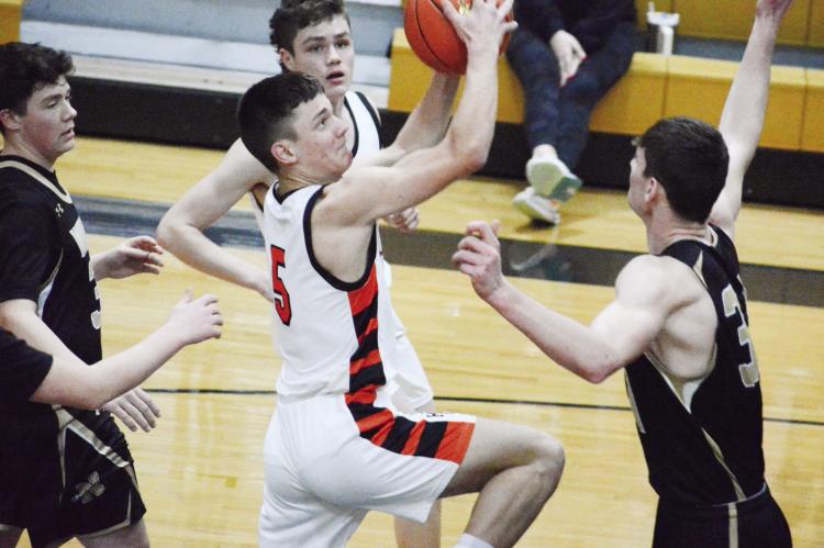 HARDIN-CENTRAL junior Kameron Pugh looks to shoot over the outstretched arm of Norborne senior Kobe Gibson Monday night at Norborne. SHAWN RONEY | Staff