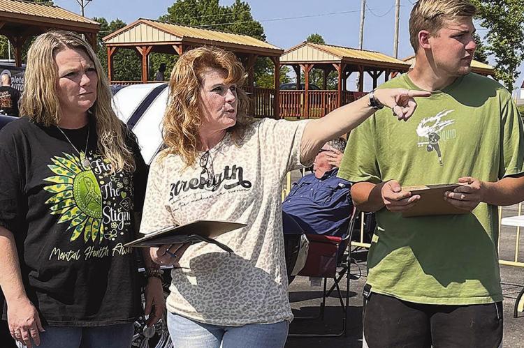 PROJECT HERO FOUNDATION co-founders Tobi Lackey (from left), Tammy Folvarcik and volunteer Aidan Dorton take preparations seriously. The three are ready for the Mental Health Awareness Week event.
