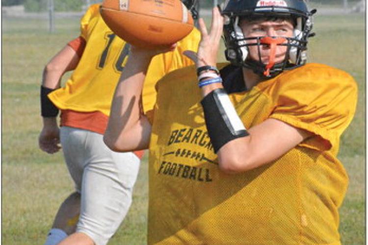 GAGE TEBBE, Orrick’s new quarterback, rears back to throw as Jaxon Miller runs a pass route behind him Monday on the Orrick practice field. SHAWN RONEY | Staff