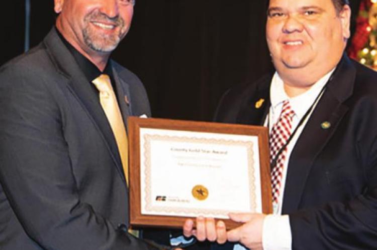 MISSOURI Farm Bureau Board member Jason Kurtz presents a Gold Star Awards program plaque to Joe Robinson.