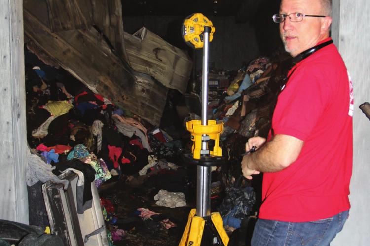RICHMOND Salvation Army Director Phil Powers shows fire damage makes a shambles of the organization’s new building.