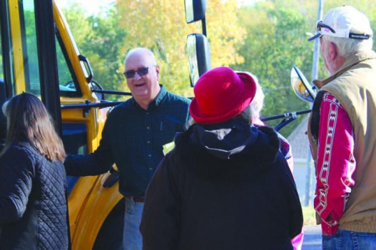 HAL MIDDLETON (second from left) ushers history tour participants onto the bus. SHARON DONAT | Staff