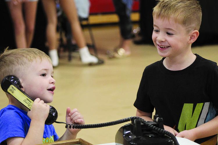 TUCKER AND BECKETT HAMM explore a rotary phone at the Ray County Historical Society and Museum booth during the ForFFA Summer Bash held at Richmond High School. SHARON DONAT | Staff