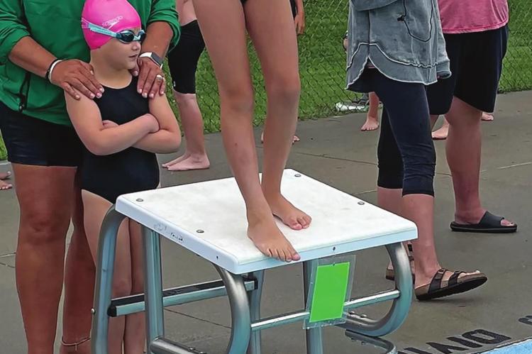 HADLEY BURGESS gets ready to jump off the block during the Dolphins’ swimming meet July 10 at Southview Pool in Richmond. Behind her are teammate Deliah Fewins and coach Angela Pencook. SUBMITTED Photos