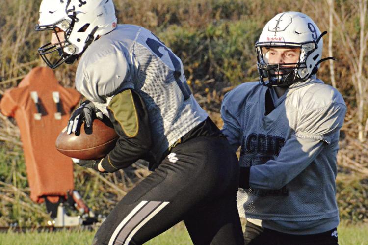 GAGE SMITH (No. 21) takes a handoff from Norborne Hardin-Central quarterback Brody Fifer late in practice Monday at Hardin-Central. SHAWN RONEY | Staff