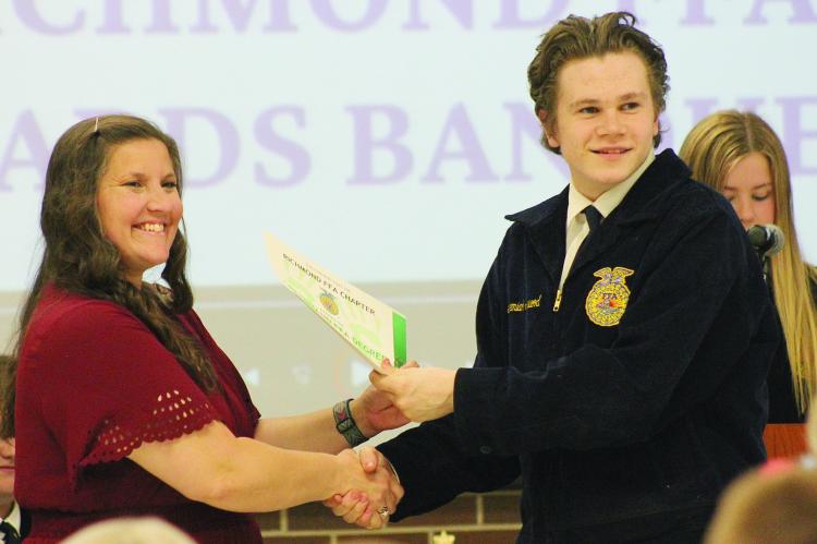 FFA ADVISOR LAURA ALLEN (LEFT) presents an award to high school student Jeremiah Silkwood. SOPHIA BALES | Staff