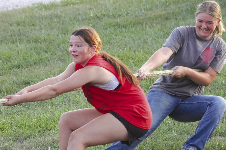SYNDEE BURNETT (left) and Addison Burk pull with all their might during the tug-o-war event.