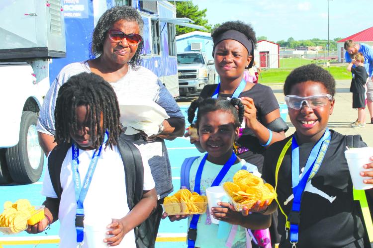 MARTHA STANDLEY (from left), Courtland Caroline, Chani Underwood, Royalty Caroline and Leslie Caroline grab nachos before heading home.
