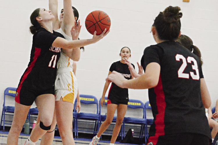 CANDIACE CLAYPOLE (left) attempts a reverse layup against Cameron as her Richmond teammates watch at the Husker Classic. SHAWN RONEY | Staff