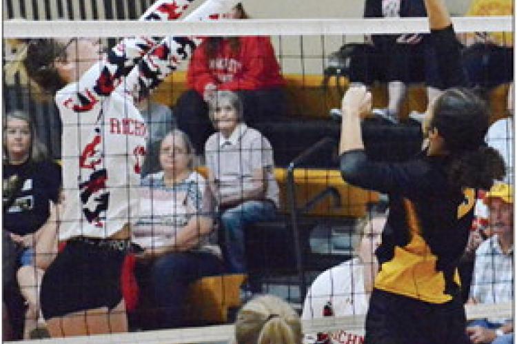KAYLEE KING (left) attempts to block a tip shot by Orrick hitter Anela Fletcher Sept. 7 in the Orrick High School gym.
