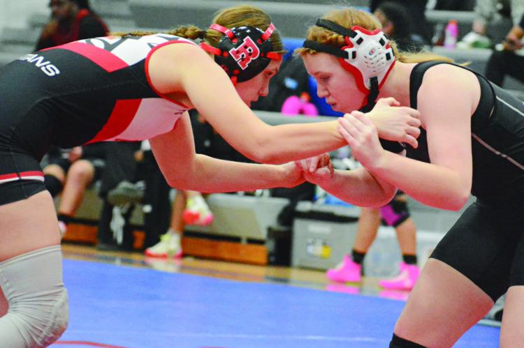 TAYLOR BAKER (left) of Richmond engages in hand fighting with Raytown South’s Madeline Murphy.