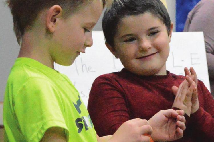 WAITING for the next song to play, Cooper Hamburg, left, talks to Laine Rowan. Songs include “Jesus Loves Me.”