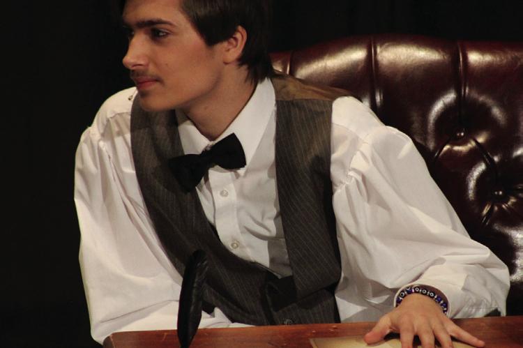 Timothy Vaughn portrays Laurie at his desk.