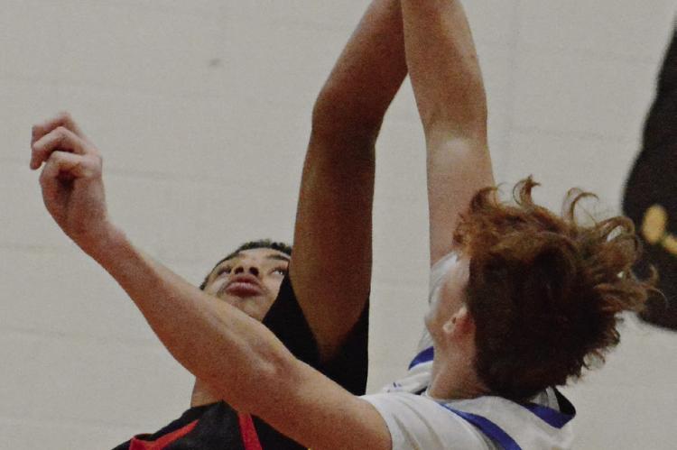 BRICE DOME (left) goes up for the tipoff during Richmond’s third-place game with Lafayette County of Higginsville.