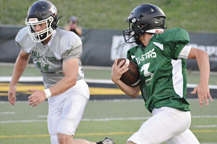 ZANDER STEVINSON, with the ball firmly tucked in his right arm, rushes as Braden Graves pursues him during the second half of the Missouri 8-Man Football Coaches Association All-Star Game June 24 in St. Joseph. SHAWN RONEY | Staff