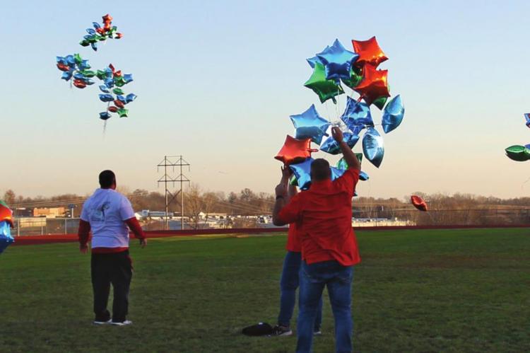 DOZENS OF BALLOONS fly from the middle of the Richmond High School football field in celebration of International Day for People with Disabilities.