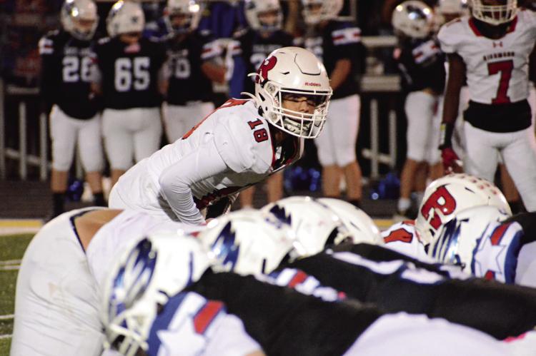 RICKY RUSS (No. 18) peers over the line of scrimmage, ready to attack, during the second of Richmond’s Oct. 6 road meeting with Holden. SHAWN RONEY | Staff