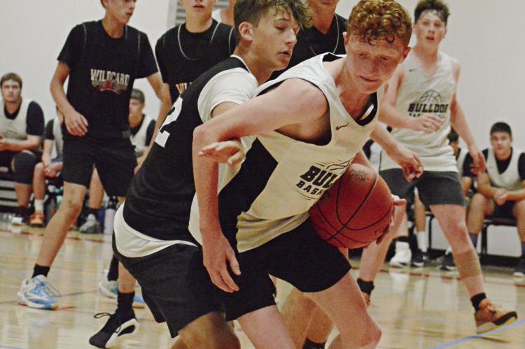 WITH THE BALL in his left hand, Hardin-Central’s Kaden McGinnis looks to dribble out of a crowd Monday at Lawson against Stewartsville/Osborn. SHAWN RONEY | Staff