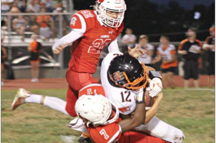 RICHMOND JUNIOR CHRIS WEBB (No. 7) tackles Oak Grove’s Jordan Hall as fellow Spartan Will Robinson closes in Sept. 1 at Richmond. SOPHIA BALES | Staff