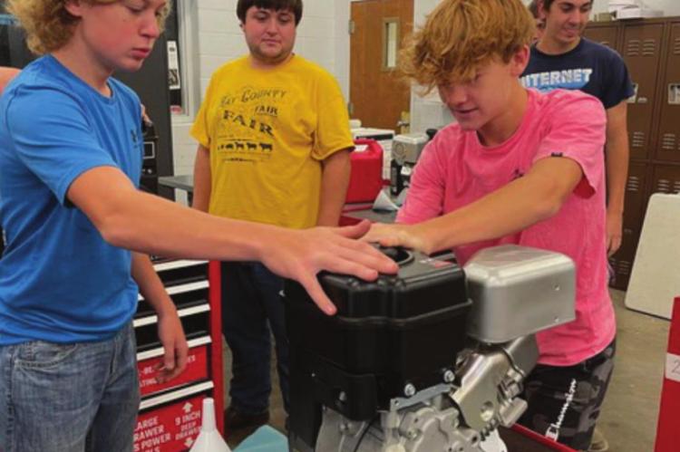 IN AN EARLY stage of learning for the class, Xander Carpenter and Wyatt Rice work on a small engine.