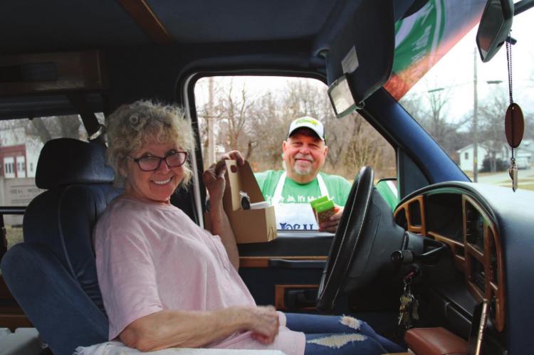 CURBSIDE SERVICE: Linda Pigg accepts a lunch serving from Kenny Goetz. J.C. VENTIMIGLIA | Staff