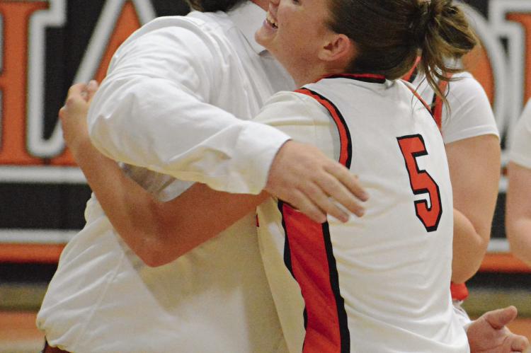HARDIN-CENTRAL SENIOR Ester Kincaid (right) receives a hug from her coach, Tommy Burton, after she surpasses 1,000 career points. SHAWN RONEY | Staff
