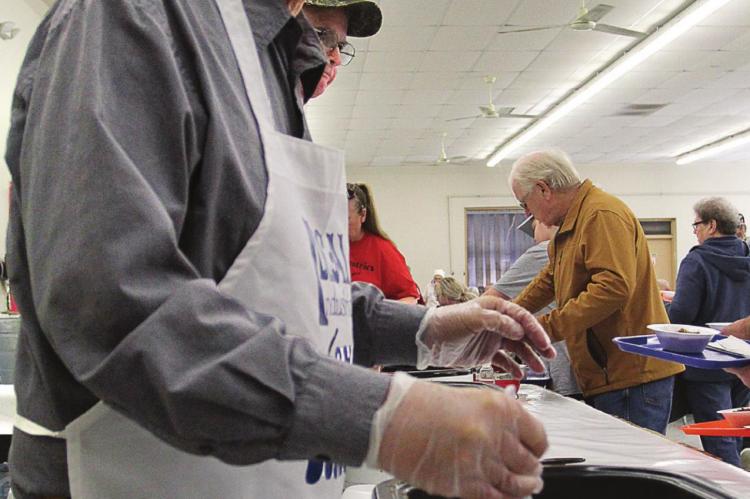 BOARD MEMBER Kenneth Nolker fills bowls and keeps the line moving.